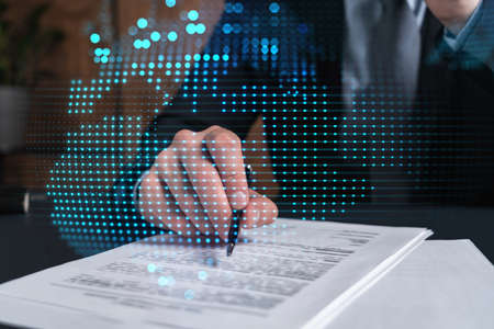 Businessman in suit signs contract. Double exposure with world map hologram. Man signing agreement...
