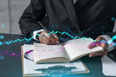 Financial stock market graph hologram and a woman taking notes. Business education and analysis...