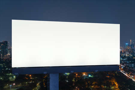 Blank white road billboard with Bangkok cityscape background at night time. Street advertising poster, mock up, 3D rendering. Front view. The concept of marketing communication to promote idea.の写真素材