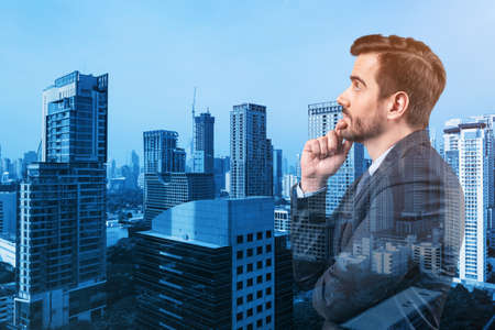 Young handsome businessman in suit with hand on chin thinking how to succeed, new career opportunities, MBA. Bangkok on background. Double exposure.の写真素材