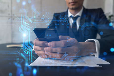 Businessman in office working with Smartphone, new technologies hologram to optimize the process, typing phone. Double exposure.の写真素材