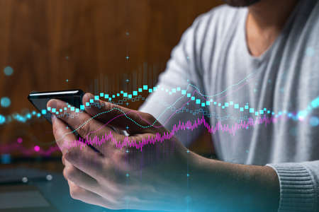 Man using phone. Hands typing smartphone. Double exposure with forex graph hologram. Close up. Financial chart and analysis concept. On-line trading and investment.の写真素材