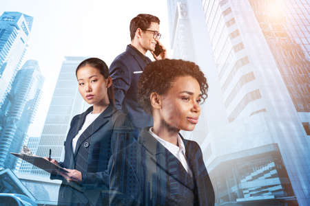 Group of four business colleagues in suits working and dreaming about new career opportunities after MBA graduation. Concept of multinational corporate team. Singapore on background. Double exposure.の写真素材