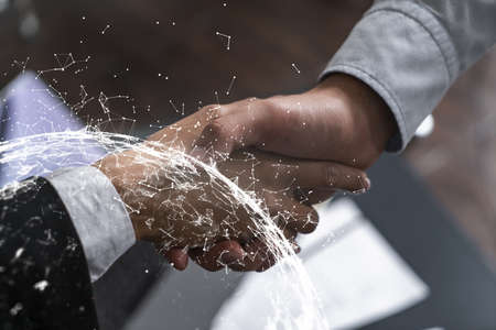 Double exposure of two businesspeople handshake and abstract technology hologram drawing background....
