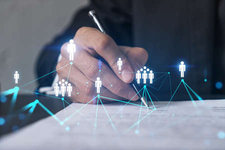 Businessman in suit signs contract. Double exposure with social network hologram. Man signing agreement on smm and analysis. International network concept.の写真素材