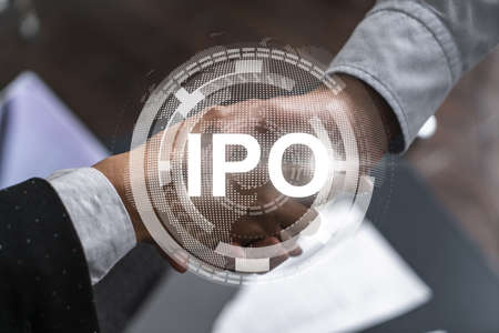 Multiexposure of two businesspeople handshake and initial primary offering, IPO hologram drawing background. Concept of partnership and business boost. Formal wear.の写真素材