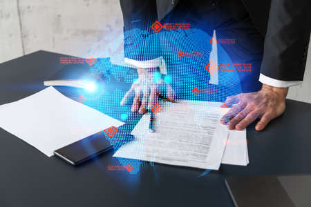 Businessman in suit signs contract. Double exposure with world map hologram. Man signing agreement...