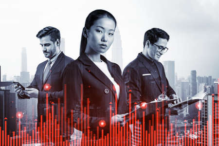 Group of business colleagues in suits as a part of multinational corporate team working on forecasting trading corporate strategy at fund. Forex chart. Kuala Lumpur on background. Double exposureの写真素材