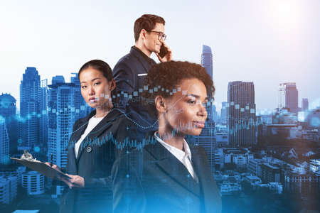 Group of business colleagues in suits as a part of multinational corporate team working on forecasting trading corporate strategy at fund. Forex chart. Bangkok on background. Double exposureの写真素材