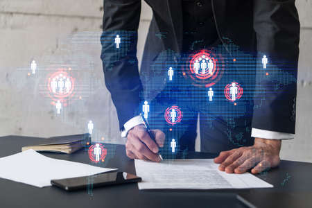 Businessman in suit signs contract. Double exposure with world map hologram. Man signing agreement...