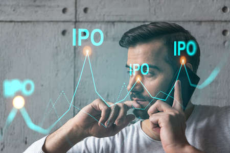 A man in casual wears, talking phone. Double exposure. The concept of new investment. IPO symbol hologram.の写真素材