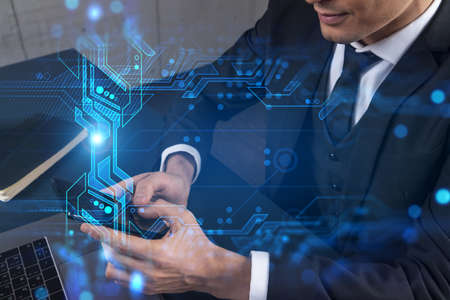 Businessman in office working with Smartphone, new technologies hologram to optimize the process, typing phone. Double exposure.の写真素材