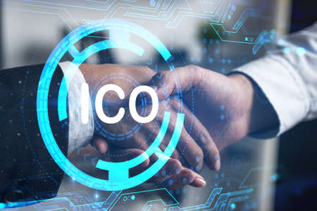 Double exposure of two businesspeople handshake and initial coin offering, ICO hologram drawing background. Concept of partnership in blockchain and cryptocurrency business. Formal wear.の写真素材