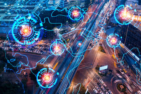World planet Earth map hologram on aerial view of road, busy urban traffic highway at night. Junction network of transportation infrastructure. The concept of success in logistics business.の写真素材