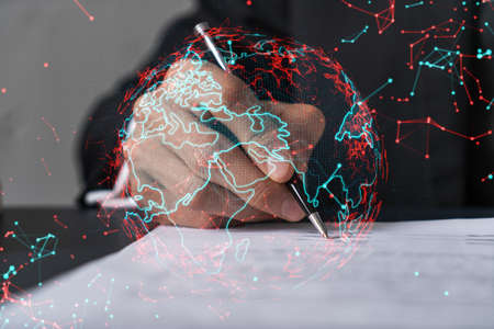 Businessman in suit signs contract. Double exposure with world map hologram. Man signing agreement international business concept.の写真素材