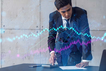 Businessman signs contract and financial chart hologram. Double exposure. Formal wear. Concept of...