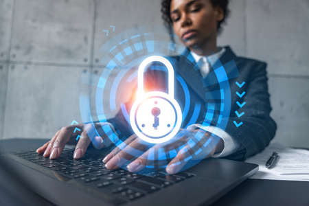 Businesswoman typing on laptop work in modern office on new project. Lock icon drawing hologram....