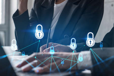 Two businesswomen working together in office. Lock icons holographic illustration double exposure.の写真素材