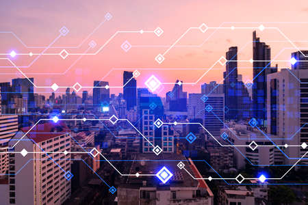 Glowing hologram of technological process, aerial panoramic cityscape of Bangkok at sunset. The...