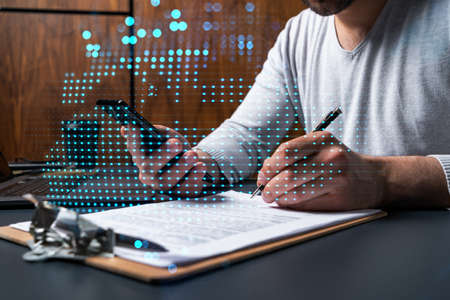 Double exposure of man signing contract with phone and world map network hologram. Concept of...