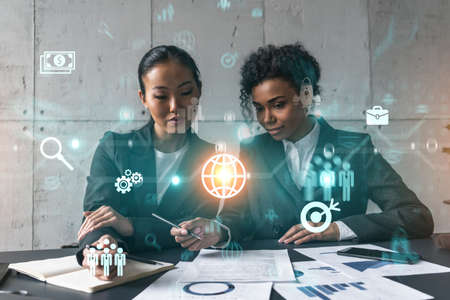 Two businesswomen work together in modern office on new project. Double exposure. Concept of...