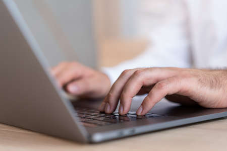 Male hands office manager typing on laptop, closeup of man hands on black keyboard. Man office...