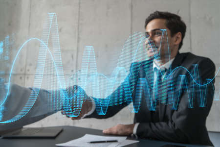 Two businessman shaking hands and financial graph hologram. Double exposure. Concept of international market trading. Handshake.の写真素材
