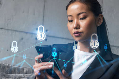 Businesswoman using phone, work in modern office on new project. Double exposure. Concept of success. Lock security hologram.の写真素材