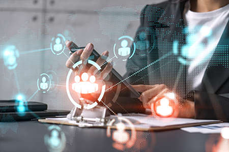 Businesswoman using smart phone in office. Social media icon hologram. Business network concept....