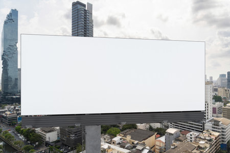 Blank white road billboard with Bangkok cityscape background at day time. Street advertising poster, mock up, 3D rendering. Front view. The concept of marketing communication to promote or sell idea.の写真素材
