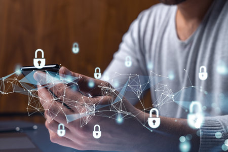 A programmer is browsing the Internet in smart phone to protect a cyber security from hacker attacks and save clients confidential data. Padlock Hologram icons over the typing hands.の写真素材