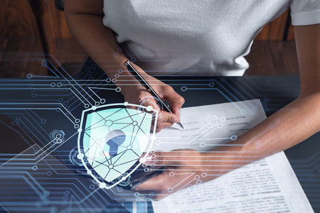 A businesswoman in casual wear signing the contract to prevent probability of risks in cyber security. Checking the phone. Padlock Hologram icons over the working desk. Women in business concept.の写真素材
