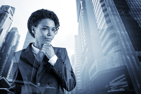 Attractive black African American business woman in suit with hand on chin thinking how to succeed, new career opportunities, MBA. Singapore on background. Double exposure.の写真素材