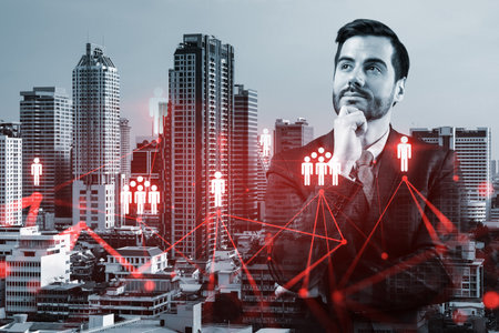 Handsome Caucasian HR director at international company is thinking about efficient strategy to recruit highly qualified specialists. Social media and marketing hologram icons over Bangkok background.の写真素材