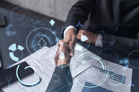 Handshake of two businesswomen who enters into the contract to develop a new software to improve business service at a company. Technological icons over the table with the document.の写真素材