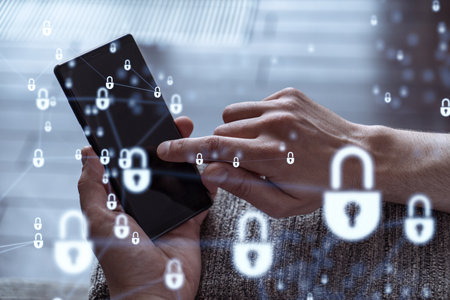 A programmer is browsing the Internet in smart phone to protect a cyber security from hacker attacks and save clients confidential data. Padlock Hologram icons over the typing hands.の写真素材