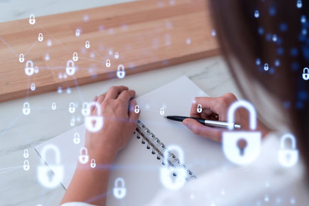 Businesswoman is taking notes of clients needs to protect cyber security from hacker attacks and save clients confidential data. Padlock Hologram icons over the typing hands. Formal wearの写真素材