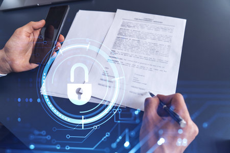 A businessman in formal wear signing the contract to prevent probability of risks in cyber security. Padlock Hologram icons over the working desk.の写真素材