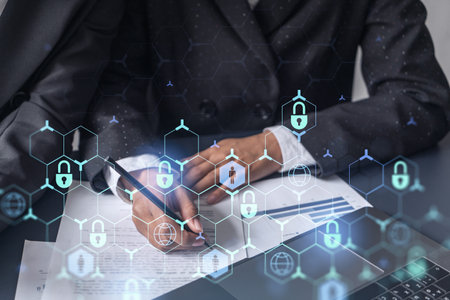 Two businesswomen working on the project to protect cyber security of international company. Padlock Hologram icons over the table with documents.の写真素材