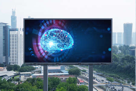 Brain hologram on billboard with Kuala Lumpur cityscape background at day time. Street advertising...
