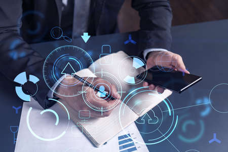 Arm in formal wear writing down some ideas using phone to create innovative software to provide a...