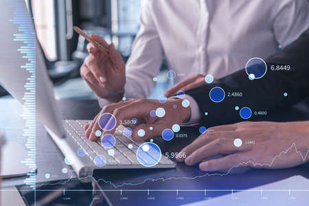 Two traders man and woman researching historic data to predict stock market behavior using laptop....