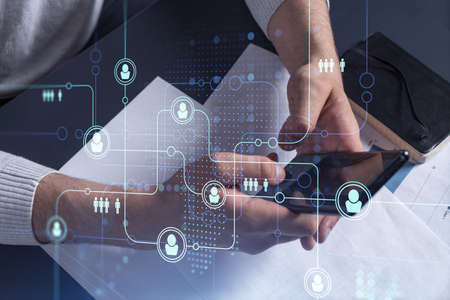 Hands of hr specialist browsing social networks in the Internet in smart phone to find the best...