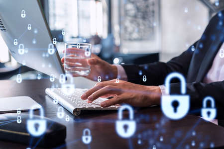 A programmer is typing a code on computer to protect a cyber security from hacker attacks and save...