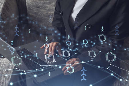 Woman typing the keyboard to create innovative software to change the world and provide a completely new service. Close up shot. Hologram tech graphs. Concept of Dev team. Formal wear.の写真素材