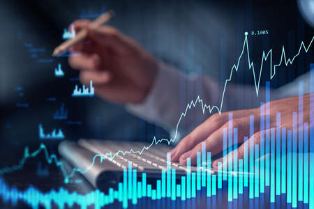 Hands typing the keyboard to research stock market to proceed right investment solutions. Internet...