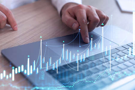 Hands typing the keyboard to research stock market to proceed right investment solutions. Internet...