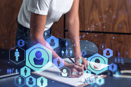A woman HR specialist is taking notes concerning new candidates to create international network in...