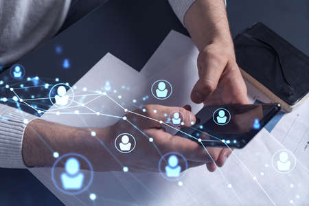 Hands of hr specialist browsing social networks in the Internet in smart phone to find the best...
