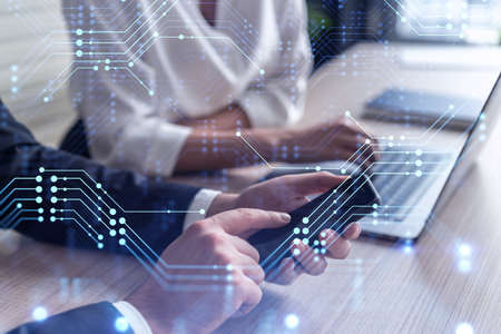 Two research and development specialists brainstorming on project to create a new approach to develop software to improve business . Working with phone. Tech hologram icons. Formal wear.の写真素材